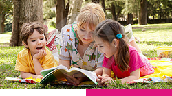 Vision Rehabilitation Services & Training Programs; Three children lying on a grassy field reading a book