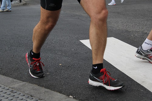 A group of marathon runners is shown from the chest down in action