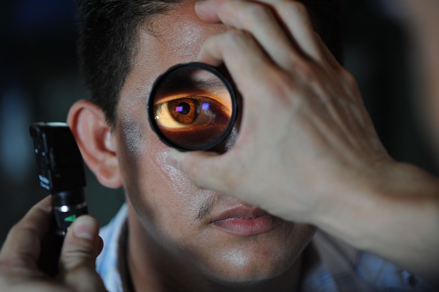 An optometrist holds equipment in front of a male patient